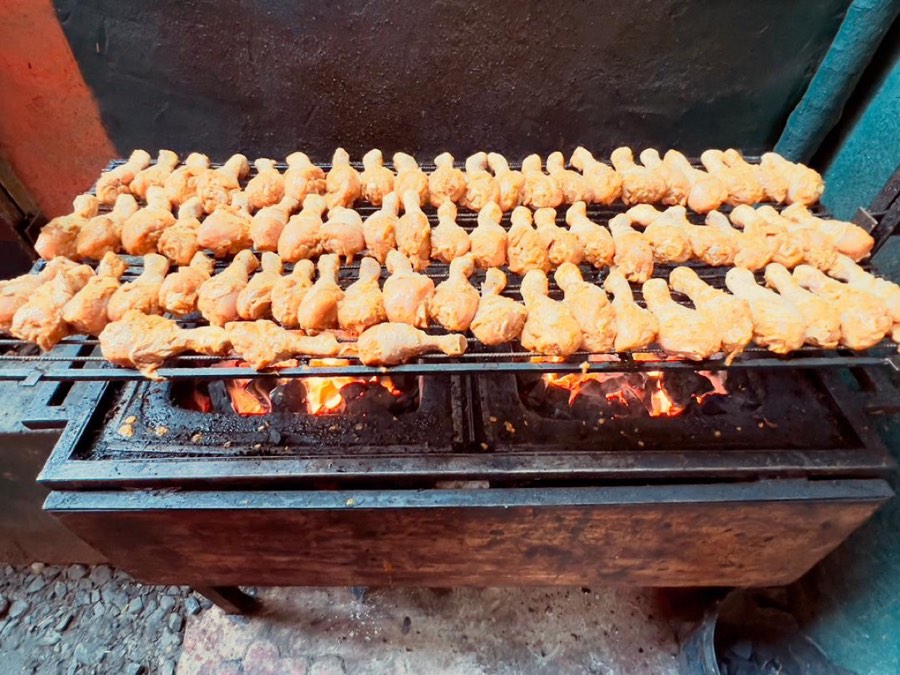 Marinated chicken pieces over a live charcoal fire